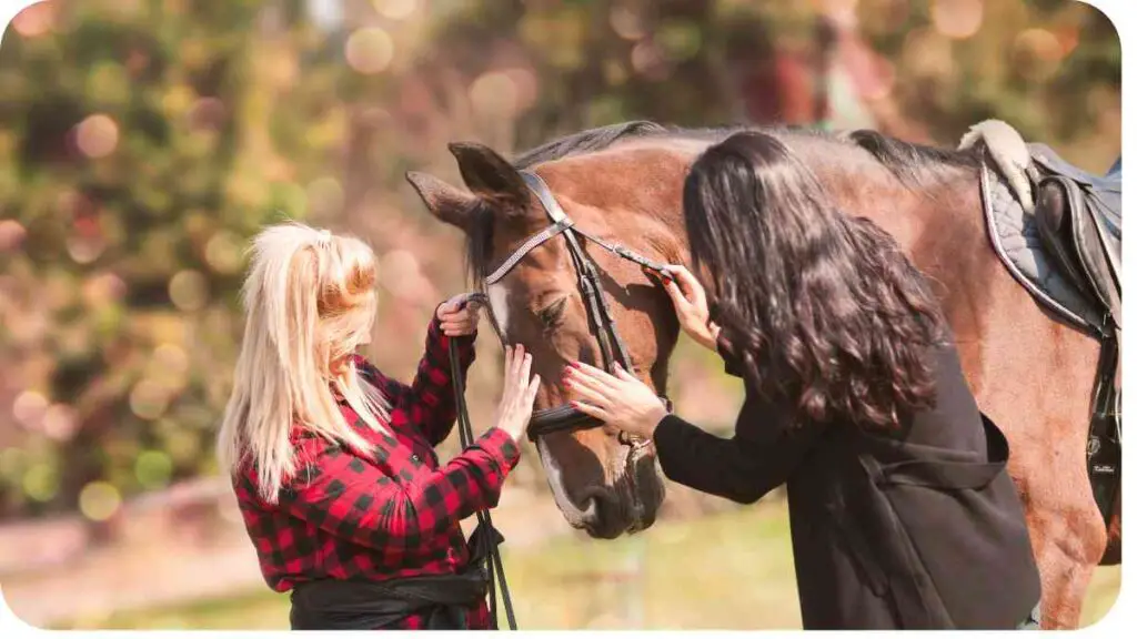 two people petting a horse in a field